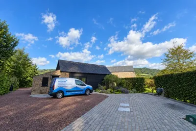 An Invicta van outside a stone barn conversion on a bright day.