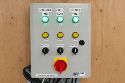 A control panel with indicator lights and selector switches for the borehole, soft and potable tanks.