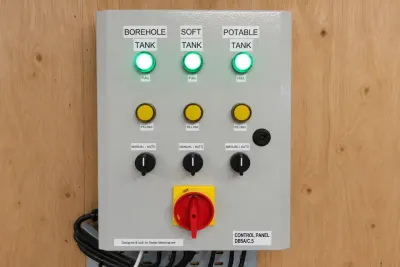 A control panel with indicator lights and selector switches for the borehole, soft and potable tanks.